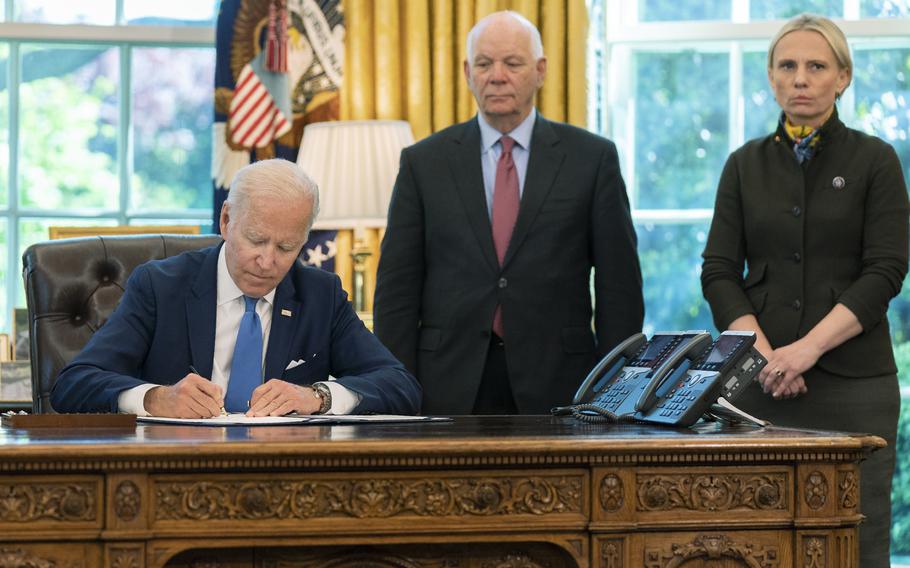 President Joe Biden signs the Ukraine Democracy Defense Lend-Lease Act of 2022 in the Oval Office of the White House, Monday, May 9, 2022, in Washington. Witnessing the signing are Ukraine-born Rep. Victoria Spartz, R-Ind., right, and Sen. Ben Cardin, D-Md. 