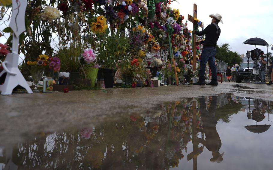 Flowers and crosses adorn a memorial.