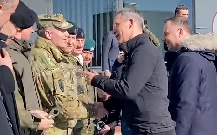 Sekretarz generalny NATO Jens Stoltenberg podaje dłoń Naczelnemu Dowódcy Sił Sojuszniczych NATO Europa Generał Sił Powietrznych USA Tod Wolters w bazie lotniczej w Łasku, Polska, 1 marca 2022 r. Stoltenberg odwiedził bazę z prezydentem Polski Andrzejem Dudą, po prawej.