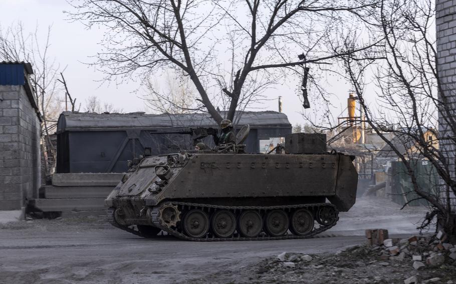 Ukrainian soldiers drive a U.S-made M113 armored personnel carrier past the Triangle.