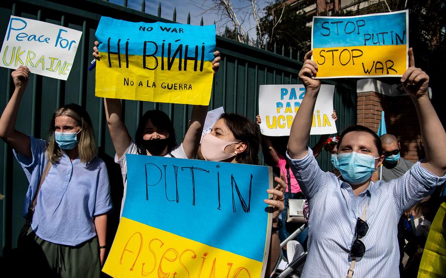 Ukrainian citizens hold posters during a protest in support of Ukraine in front of the Russian Embassy in Santiago, Chile, on Thursday, Feb. 24, 2022. 