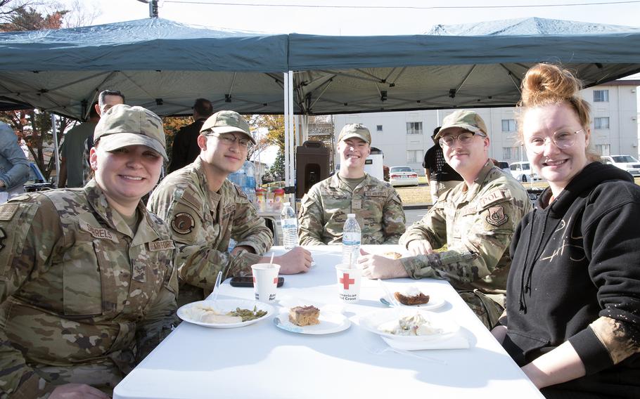 Unaccompanied service members pose during a Thanksgiving meal provided by the USO at Yokota Air Base, Japan, Tuesday, Nov. 22, 2022.