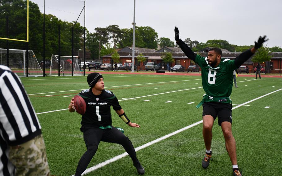 The quarterback for the U.S. Air Force team tries to find an open receiver while being pressured by the U.K. armed forces defender during a flag football game Friday at RAF Lakenheath. The New York Jets sponsored the multi-service flag football game and donated custom jerseys for each team to wear.