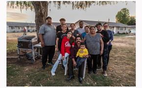 Karla Acevedo Perez, 11, sits with her mother, siblings, uncles and grandparents at the Lodi Migrant Center in October. Four generations of the Perez family have worked as migrant farmworkers in California.