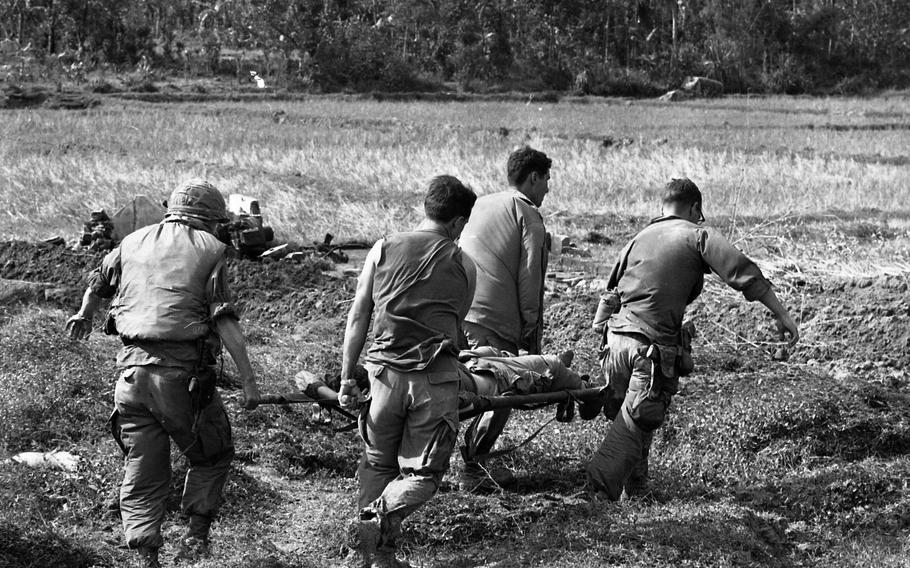 A wounded soldier is carried on a stretcher.