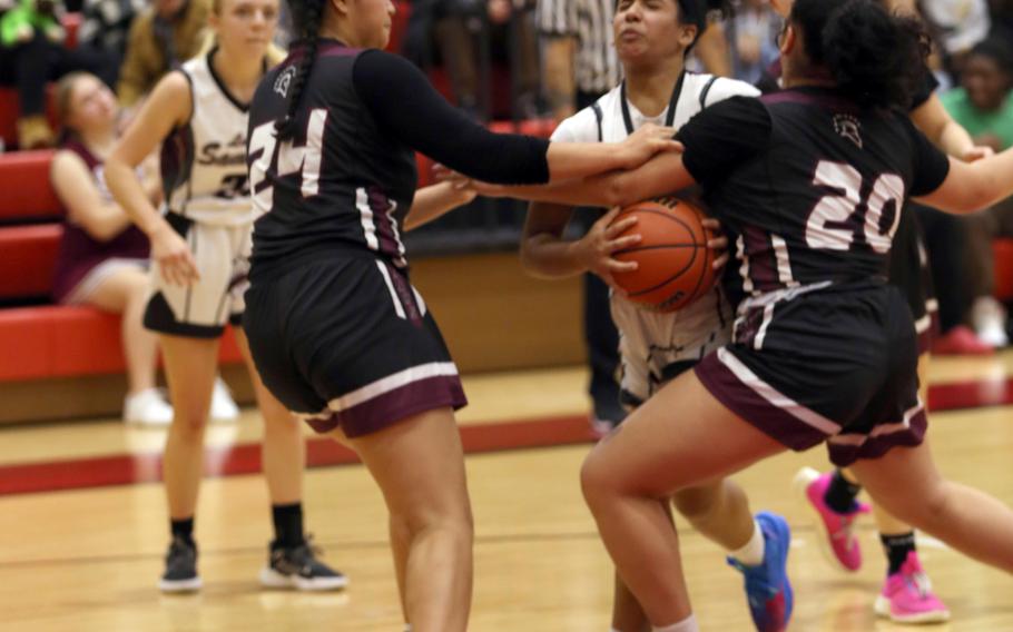 Matthew C. Perry's Ivanelis Nieves crashes into Zama's Kierstyn Aumua and Deborah McClendon during Friday's DODEA-Japan girls basketball game. The Trojans won 39-31.