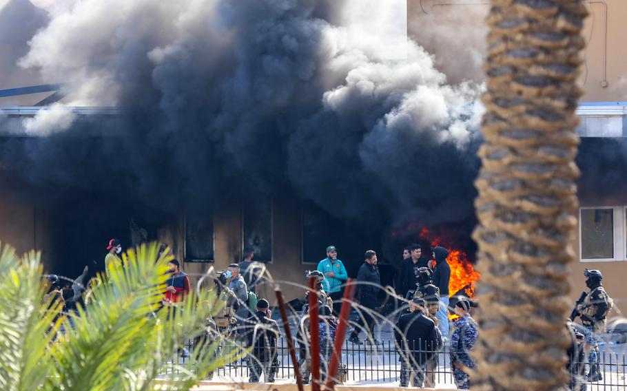 Attackers set fire to the U.S. Embassy in Baghdad as smoke rises from inside the compound, Jan. 1, 2020. 