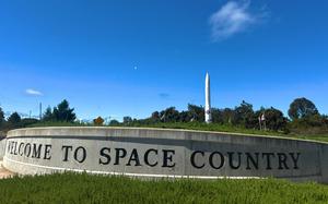 A short wall that reads “WELCOME TO SPACE COUNTRY” with a rocket in the background.