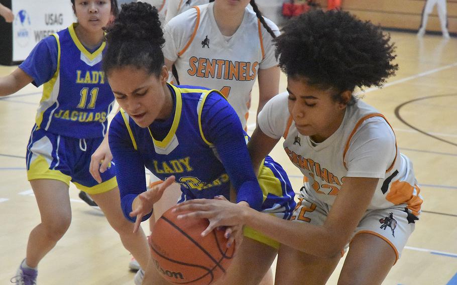 Alysia Dobbins and Brooklyn Shakir-Bacchus battle for the ball.