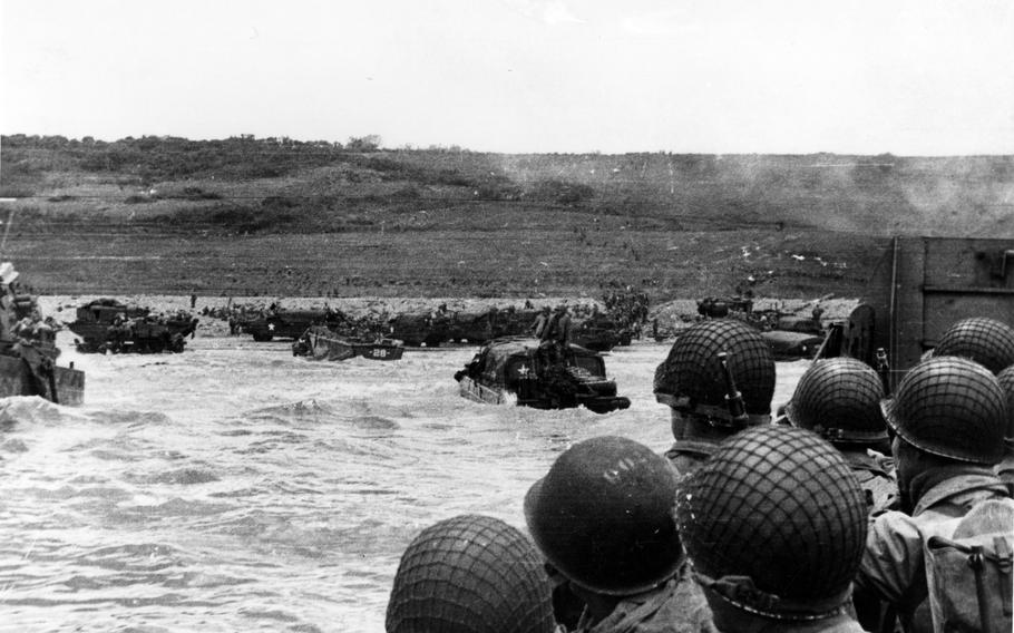 Troops watch activity ashore on Omaha Beach as their landing craft approaches on D-Day, June 6, 1944. 