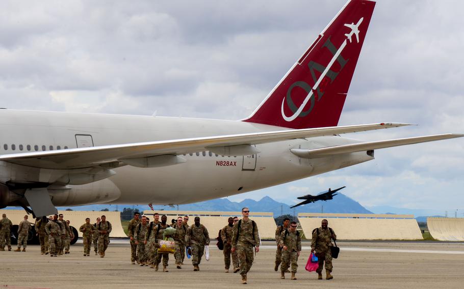 Airmen walk off an airplane