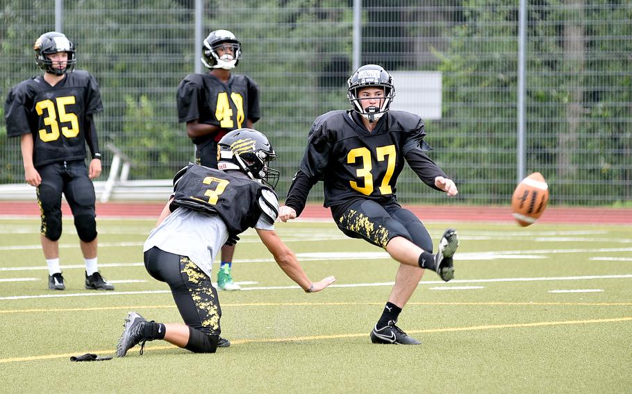 Stuttgart's Jaden Gandy kicks a field goal during an Aug. 28, 2023, practice at Stuttgart High School in Boeblingen, Germany. Holding is Chase Holmes.