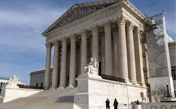 An exterior view of the front of the U.S. Supreme Court building, with stone steps leading up to columns by the entrance.