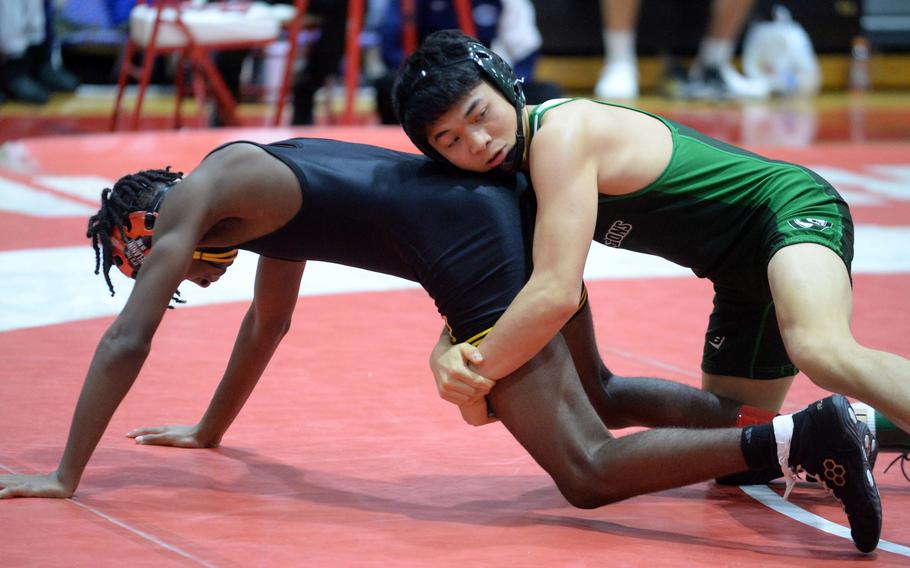 Kubasaki's Gavin Ocampo takes charge of American School In Japan's Malcolm Lee en route to a 10-0 technical-fall victory in the 122-pound final.