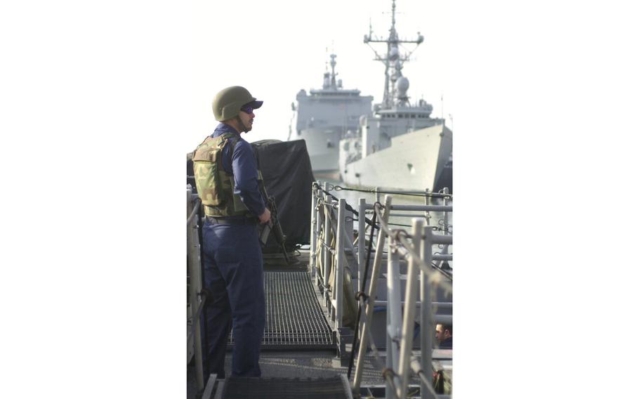 A sailor stands guard aboard the USS Typhoon at Naval Station Rota, Spain. Patrol boats USS Typhoon and USS Sirocco stopped in Rota on their way to the Persian Gulf.