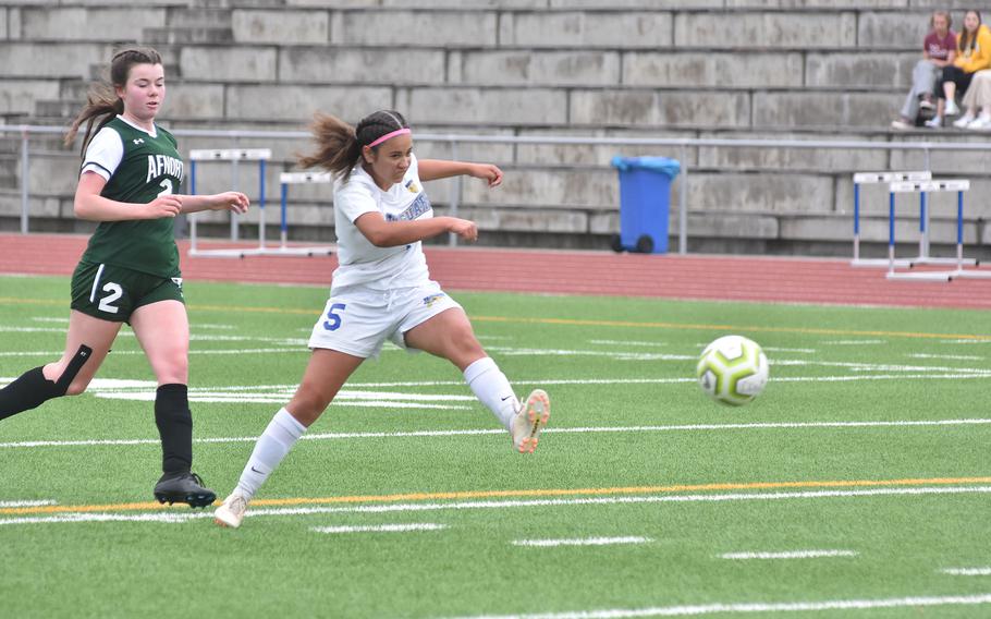 Sigonella's Charlize Caro takes a hard shot on goal Tuesday, May 16, 2023, as AFNORTH's Finja Liebing watches in the second day of the DODEA-Europe girls Division III championships at Ramstein Air Base, Germany. 