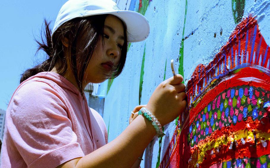Humphreys High School junior April Conner adds finishing touches to a mural at Jacob's House, an orphanage near Camp Humphreys, South Korea, June 13, 2023.