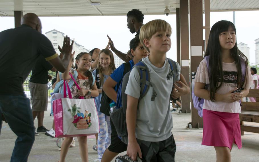 Students are greeted as they enter Humphreys Central Elementary School at Camp Humphreys, South Korea, Monday, Aug. 21, 2023. 