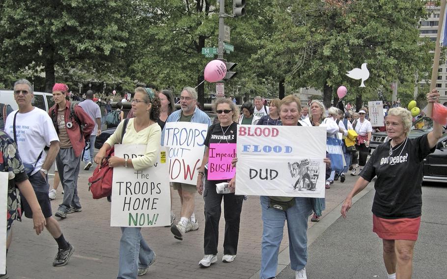 Anti-war demonstrators walk down Pennsylvania Avenue in Washington on their way to the National Mall to gather for a march past the White House.   