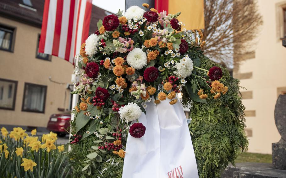 A memorial wreath with two white ribbons 