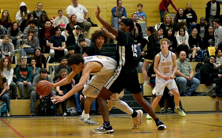 Vicenza forward Simon Gilbert stumbles in the low block as Naples senior Thurman Bruner defends in pool-play action of the DODEA European Basketball Championships on Feb. 15, 2024, at Wiesbaden High School in Wiesbaden, Germany.