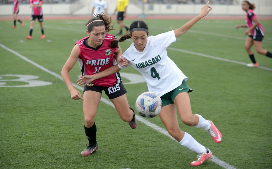 Kubasaki's Sakura Lopez and Kadena's Emmah Strong try to play the ball during Wednesday's Okinawa girls soccer match. The Dragons won 1-0.
