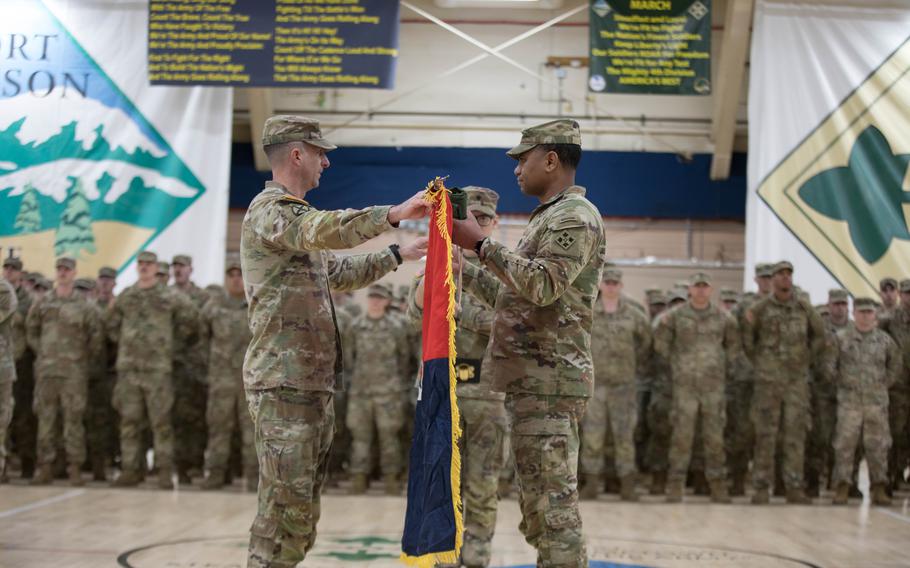 Col. Keith Benedict, commander of 2nd Stryker Brigade Combat Team, 4th Infantry Division, and Command Sgt. Maj. Joseph Cobb, senior enlisted advisor for 2SBCT, unfurl the brigade colors during an uncasing and welcome home ceremony at Fort Carson, Colo., Tuesday, March 5, 2024.