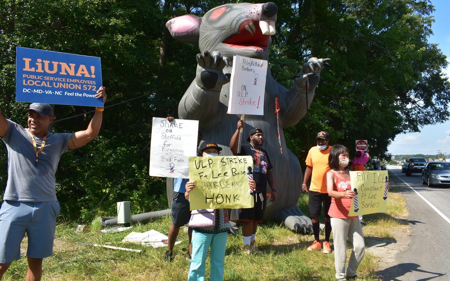 Barbers from Fort Lee shops picket in front of the Sisisky Gate at Fort Lee, Va., on June 16, 2021. They say they are being underpaid by the contractor that manages their operation.