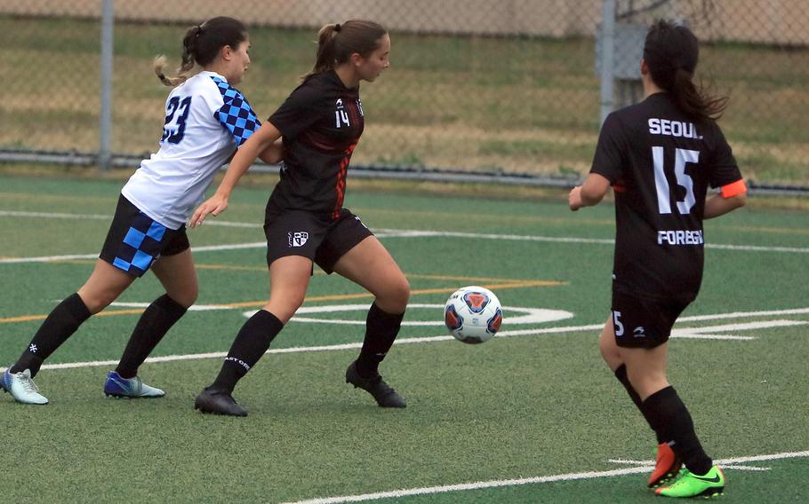 Seoul Foreign's Ana Hernandez and Skylar Won keep the ball away from Osan's Angela Serrano during Wednesday's Korea girls socceer match. The Crusaders won 5-1.