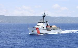 A Coast Guard cutter in water, with land visible in the background.