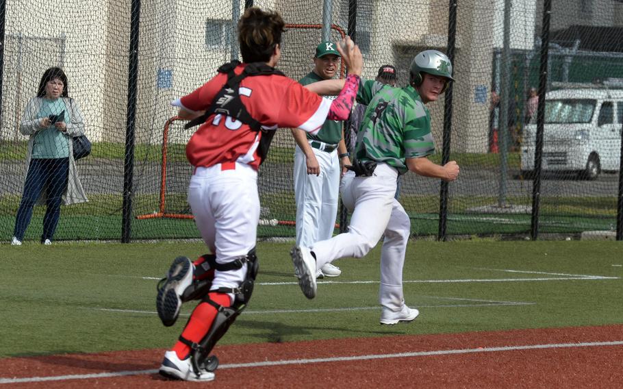 Nile C. Kinnick catcher Lance Brinkmeyer runs Kubasaki's Lukas Gaines back to third base during Monday's Division I baseball game The defending champion Dragons won 9-1.