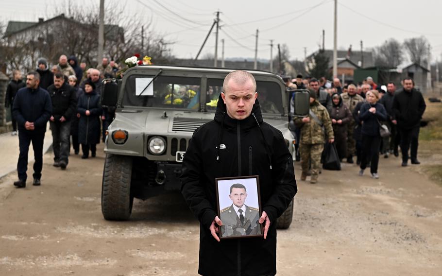 A funeral procession carrying the casket of two Ukrainian soldiers makes its way through the streets of Starychi, Ukraine, on Wednesday, March 16, 2022. The men were killed at the International Training Center by a Russian missile.