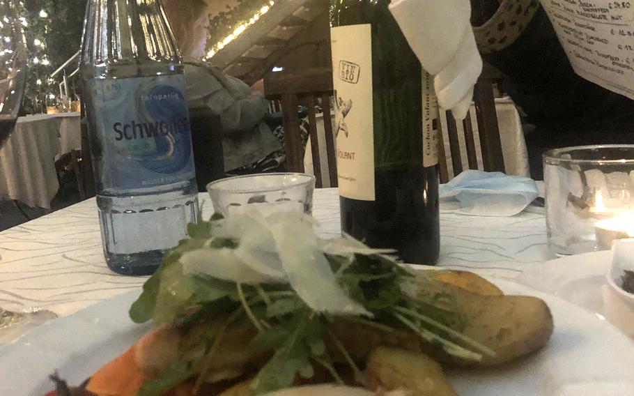 Salmon filet topped with arugula and thinly sliced Italian cheese, served with potatoes and vegetables. The dish was ordered from the prix fixe menu at Julien French restaurant in Kaiserslautern, Germany, on Sept. 1, 2021.