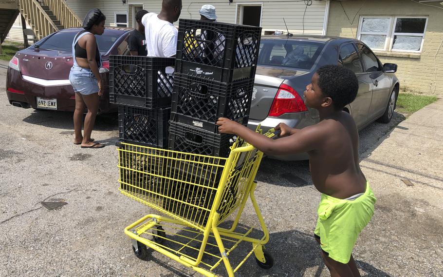 Christopher Williams, 5, pushes a shopping cart outside his family's destroyed apartment in Luling, La., on Tuesday, Sept. 7, 2021. Williams and his two brothers stack milk crates in a vacant parking lot to pass time because their toys were swept away by Hurricane Ida. They are among an estimated 250,000 children across Louisiana with no school to go to after the storm left them shuttered.