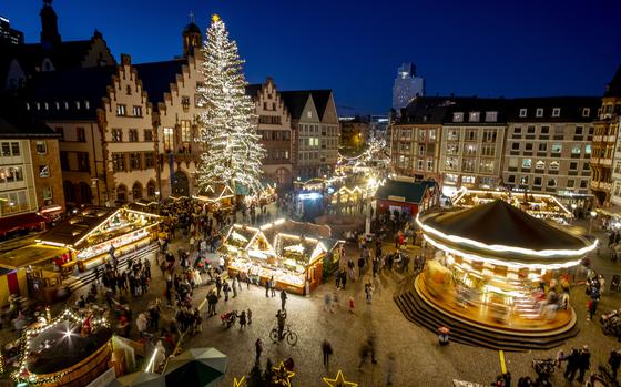 FILE - Lights illuminate the Christmas market in Frankfurt, Germany, Nov. 22, 2021. Despite the pandemic inconveniences, stall owners selling ornaments, roasted chestnuts and other holiday-themed items in Frankfurt and other European cities are relieved to be open at all for their first Christmas market in two years, especially with new restrictions taking effect in Germany, Austria and other countries as COVID-19 infections hit record highs. (AP Photo/Michael Probst, File)