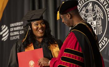 A graduate accepts their degree