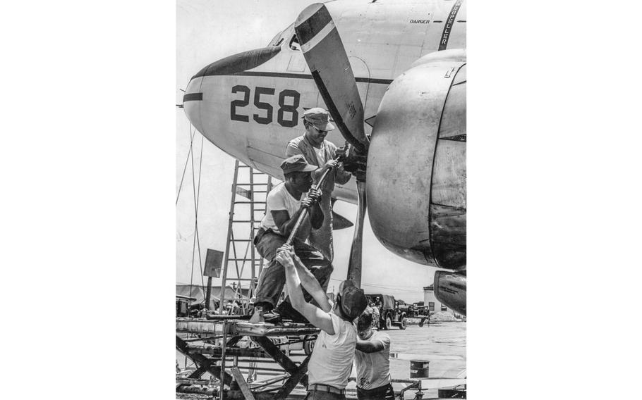 Enlisted crew members of “Supersonic Sam’s Unscheduled Airline” pitch in to change a propeller on their single R5D transport plane. The U.S. Marine crewmen are in the unit headed by Master Sgt. Sammy Dobbins, the only U.S. enlisted pilot in Vietnam at the time. They are (from top) Sgt. Leon Gibbs, mechanic; Sgt. Richard D. Wyman, crew chief; Lance Cpl. Guy W. Ealey, navigator; and Lance Cpl. Leonard U. Tippens, mechanic.