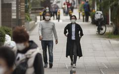 People wear masks to guard against the coronavirus while strolling in Yokohama, Japan, Nov. 20, 2020.