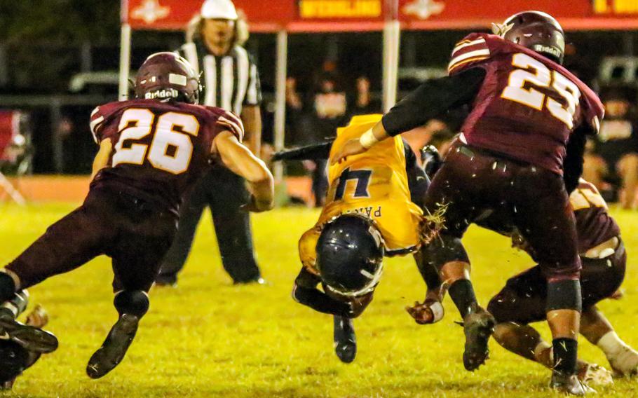 Guam High quarterback Aaron Johnson is upended by Father Duenas' Tristan Burgos and Anthony Quichocho.