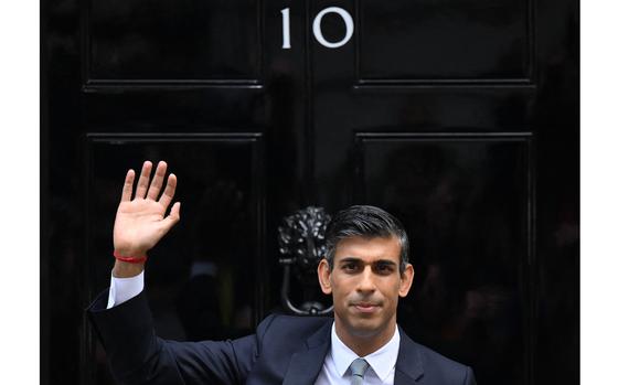 Britain's newly appointed Prime Minister Rishi Sunak waves as he poses outside to door to 10 Downing Street in central London, on October 25, 2022, after delivering his first speech as prime minister. - Rishi Sunak was on Tuesday appointed as Britain's third prime minister this year after outgoing leader Liz Truss submitted her resignation to King Charles III. (DANIEL LEAL/AFP via Getty Images/TNS)