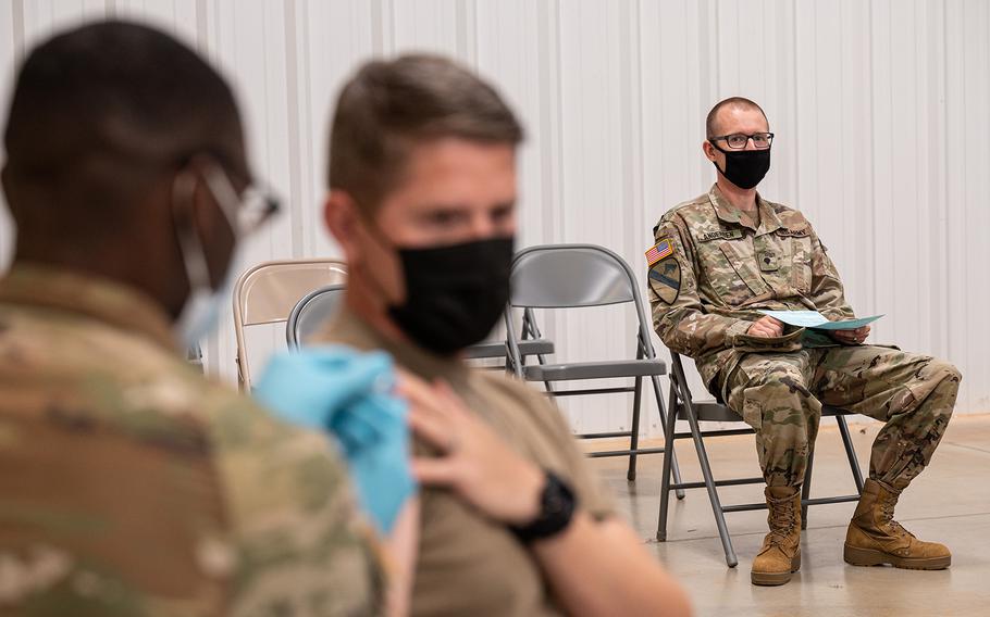 A soldier watches another soldier receive his coronavirus vaccination from Army Preventative Medical Services on Sept. 9, 2021, in Fort Knox, Ky.