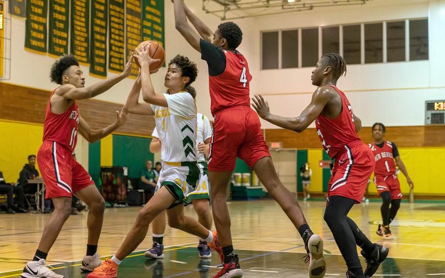 Robert D. Edgren's Micah Magat slices between Nile C. Kinnick defenders Brandon Doctor and Austin Davenport during Friday's DODEA-Japan boys basketball game. The Red Devils won 65-31.