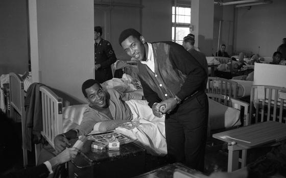 US Army Hospital, Camp Oji, Japan, Jan. 27, 1969: Marv Fleming poses for a picture with an unidentified African American patient at the U.S. Army Hospital at Camp Oji, Japan. The tight end for the Green Bay Packers is on a 17-day USO tour to military hospitals in Japan, Okinawa, the Philippines, and Hawaii together with fellow pro footballers Joe Namath of the New York Jets, Jim Otto of the Oakland Raiders, Steve Wright of the New York Giants and NBC sportscaster Charlie Jones.

Looking for Stars and Stripes’ coverage of the Vietnam War? Subscribe to Stars and Stripes’ historic newspaper archive! We have digitized our 1948-1999 European and Pacific editions, as well as several of our WWII editions and made them available online through https://starsandstripes.newspaperarchive.com/

META TAGS:  sports; NFL; football; National Football League; USO; United Service Organizations; celebrity; footballers; military hospital; wounded warriors; casualties; U.S. Army; athlete; military medical; African American
