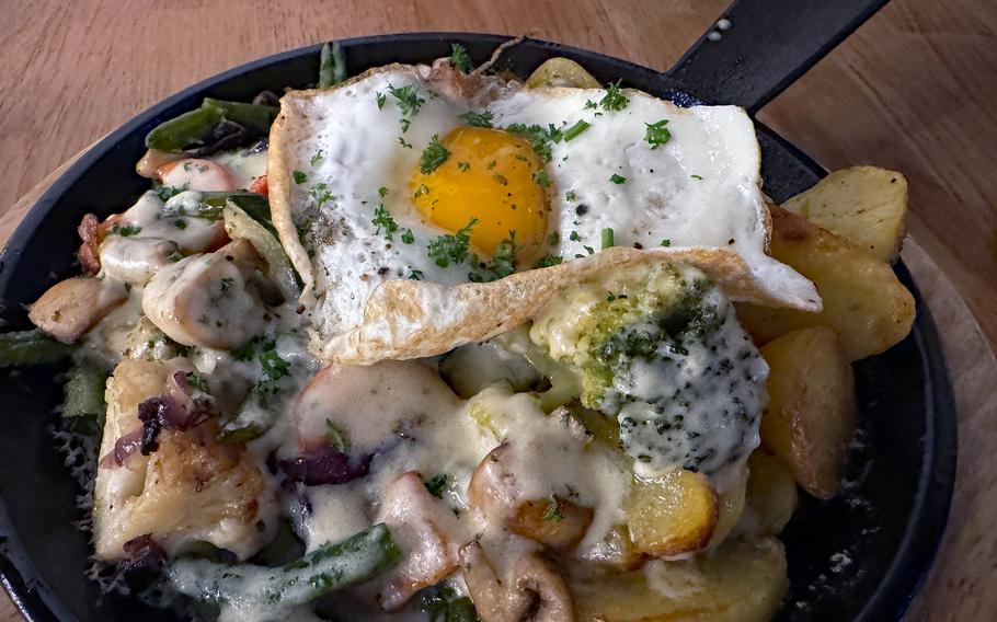 A pan with fried vegetables and egg.