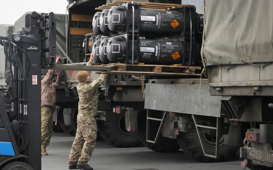 Ukrainian servicemen load Javelin anti-tank missiles, delivered as part of the United States of America's security assistance to Ukraine, into a military trucks at the Boryspil airport, outside Kyiv, Ukraine, Friday, Feb. 11, 2022.