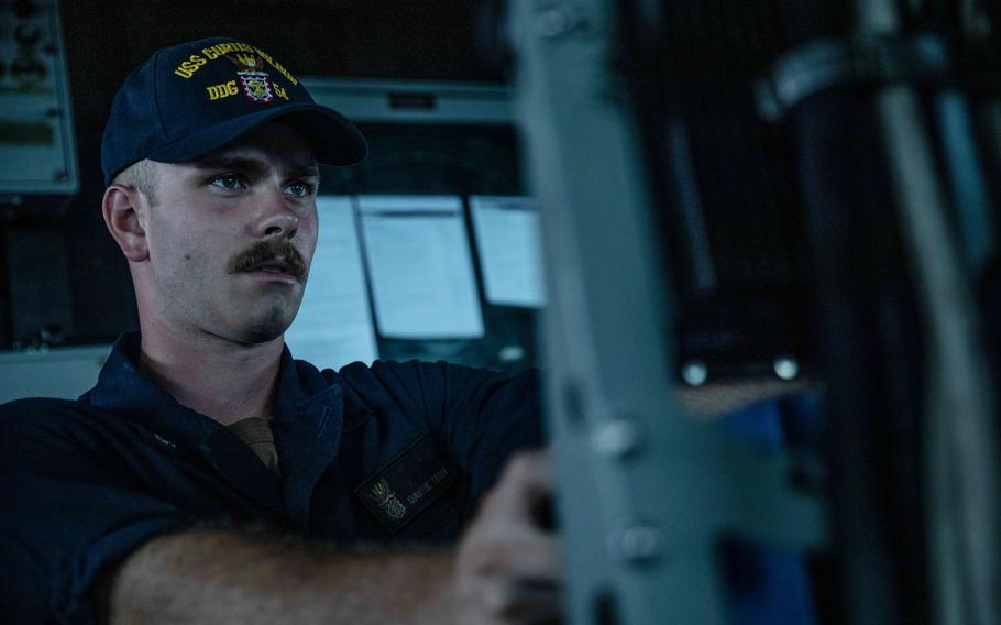 Petty Officer 3rd Class David Feder stands watch as the guided-missile destroyer USS Curtis Wilbur sails through the Taiwan Strait, Tuesday, June 22, 2021. 