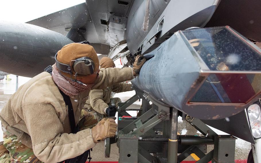 Air Force Staff Sgt. Nate Maddox and Tech. Sgt. Ryan Keel prepare an F-16 Fighting Falcon to receive a Sniper Advanced Targeting Pod in Swanton, Ohio, on Jan. 26, 2023. Poland was recently approved for a $125 million purchase to equip its warplanes with the pods.