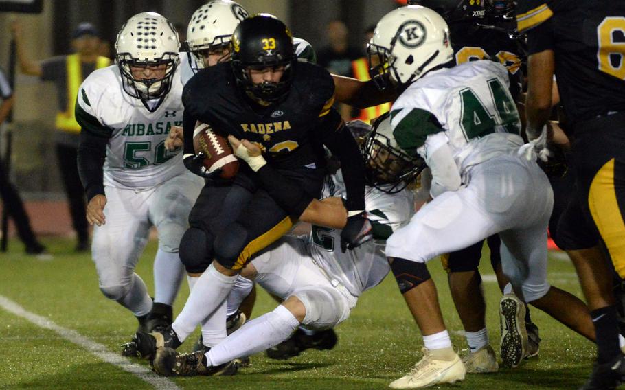 Kadena running back Flint Barton finds himself hemmed in by Kubasaki defenders.