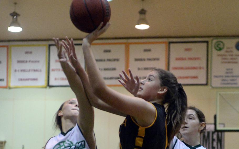 Kadena's Presley Pearce puts up a shot over Kubasaki's Jacquilline Mitchell and Emma Coffey during Thursday's season-opening Okinawa basketball game. The Panthers won 48-2.