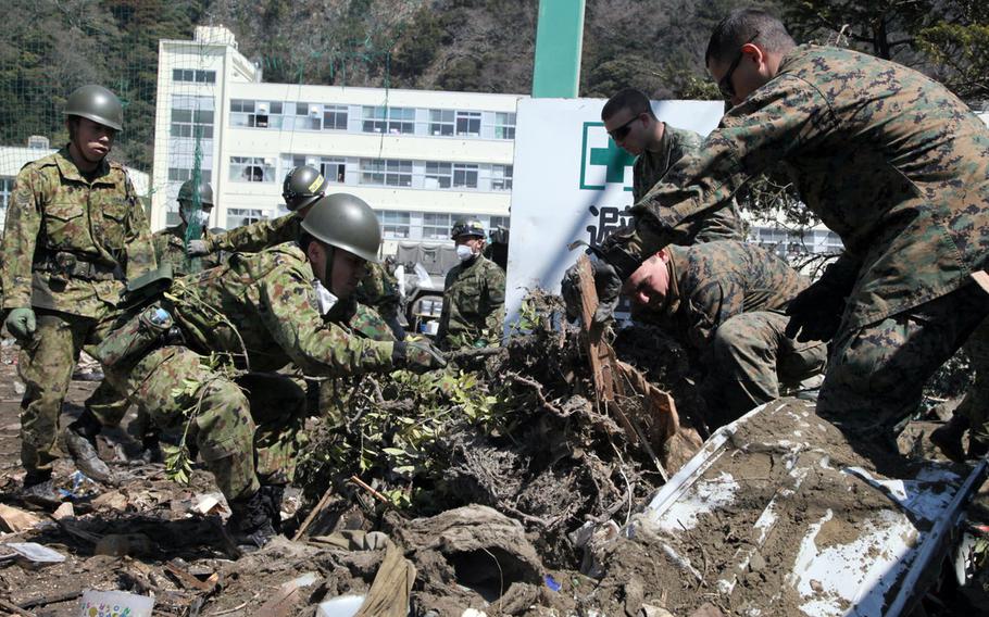 U.S. Marines and Japanese soldiers work together to clear debris at a school in Ishinomaki, Japan, April 1, 2011. The troops were participating in Operation Tomodachi, a joint humanitarian assistance operation in response to the 9.0-magnitude Tohoku earthquake and tsunami that struck northeastern Japan on March 11, 2011. 